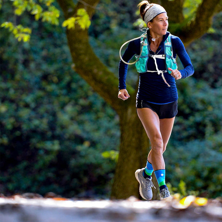 Woman running in compression crew socks with moonlit mountains design in blue